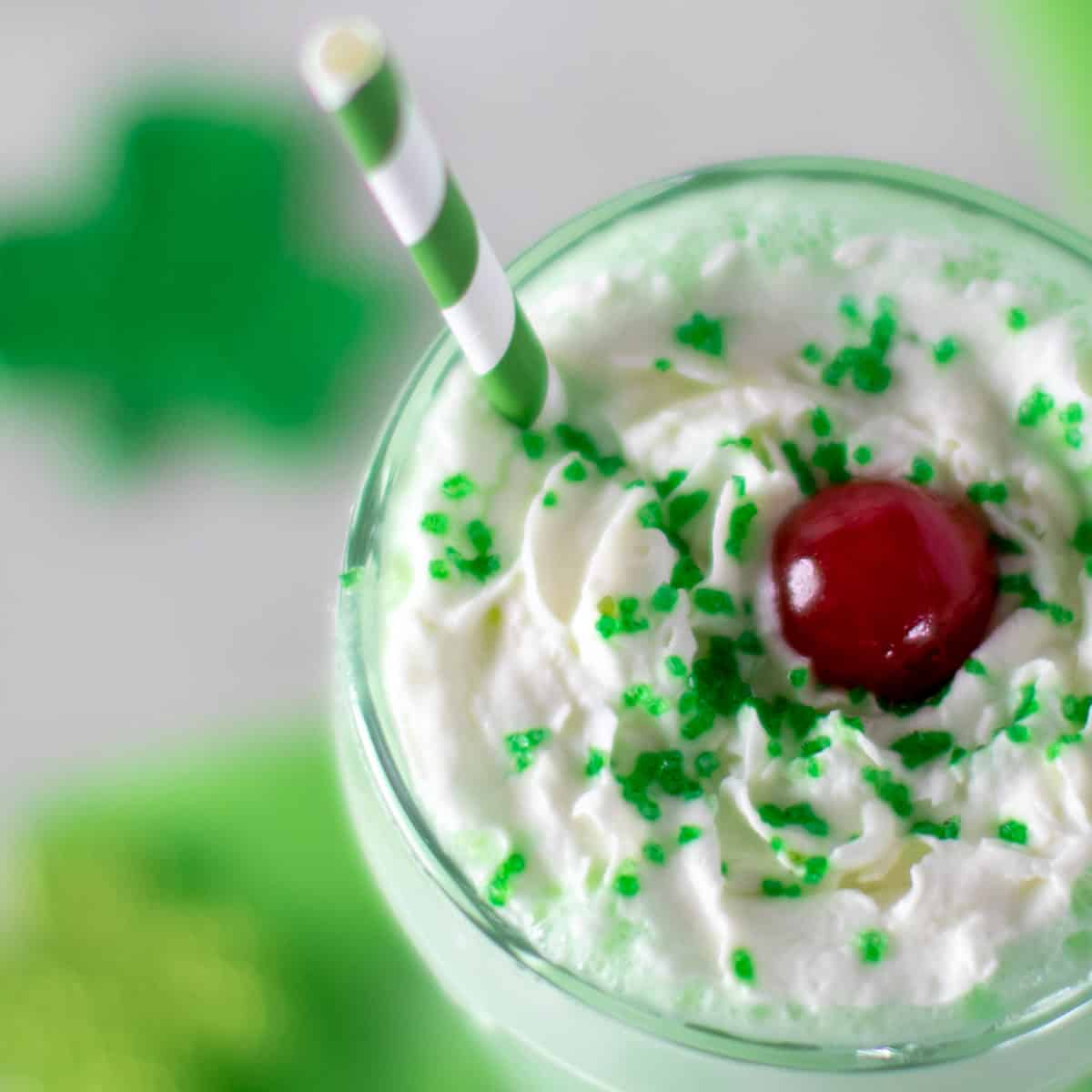 Overhead picture of milkshake with whipped cream and a cherry.