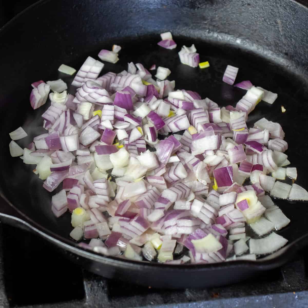 A skillet with diced red onion.