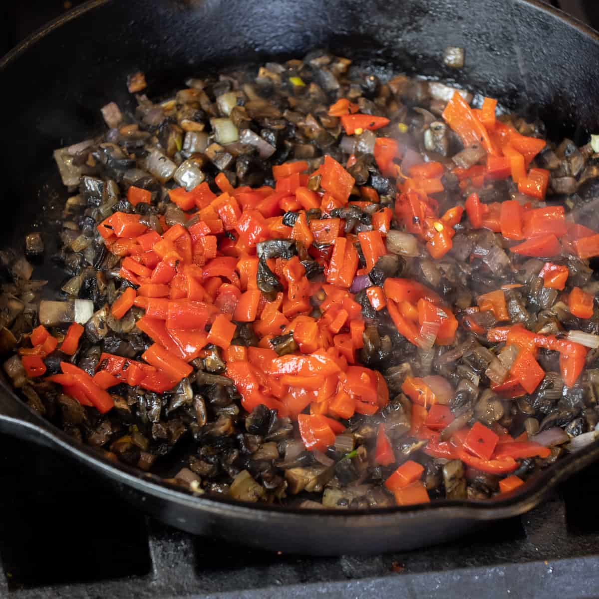 Roasted red pepper and mushrooms in a skillet.