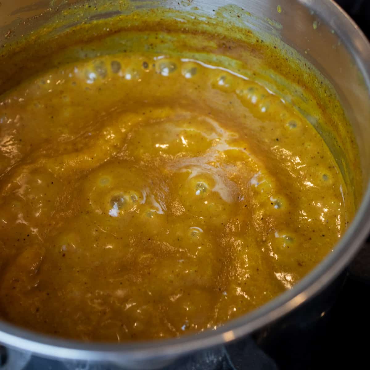 Mustard sauce bubbling in a saucepan.