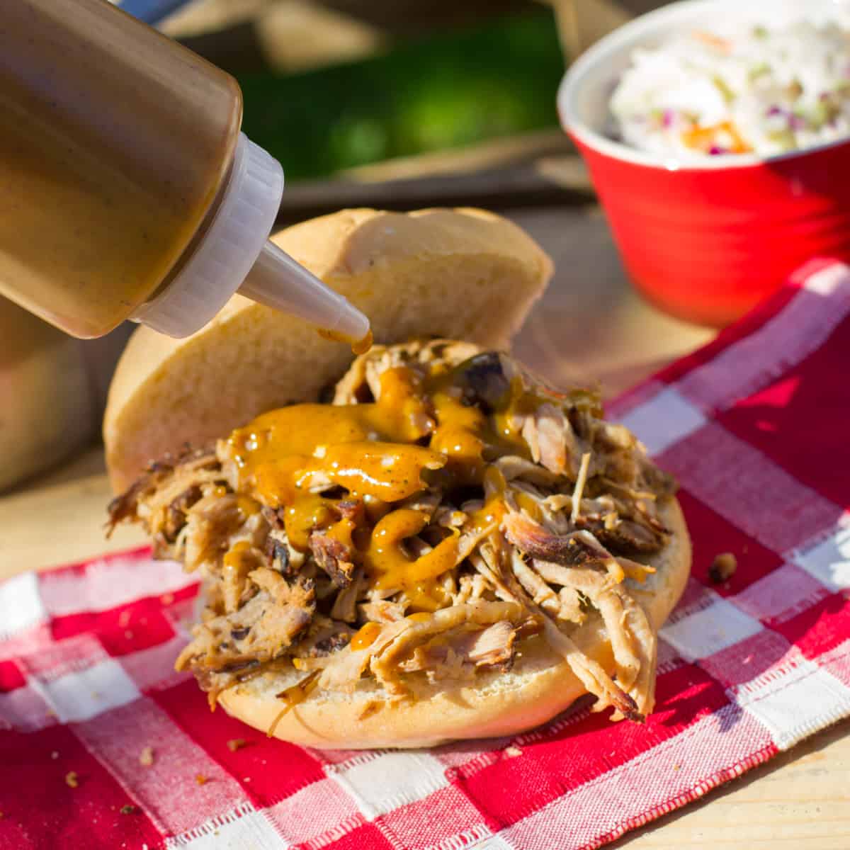BBQ squeezing on a bun with pulled pork 