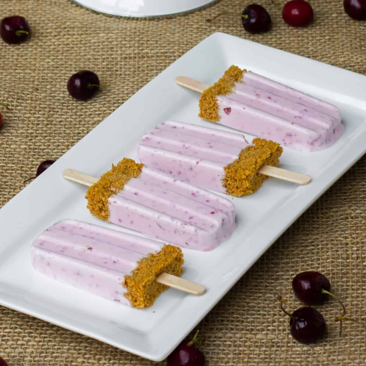 Four popsicles on a white plate.