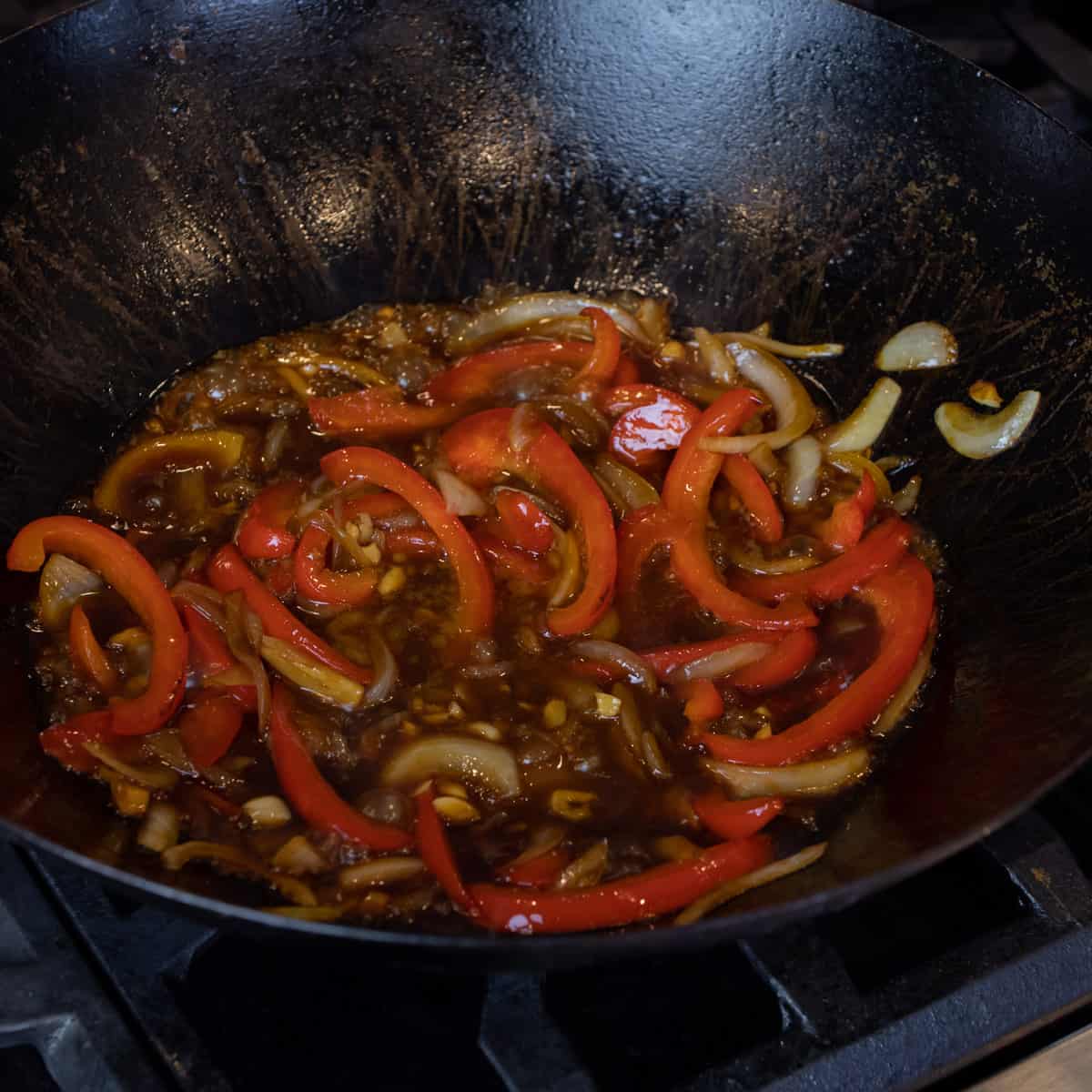 Vegetables and sauce simmering in a wok.