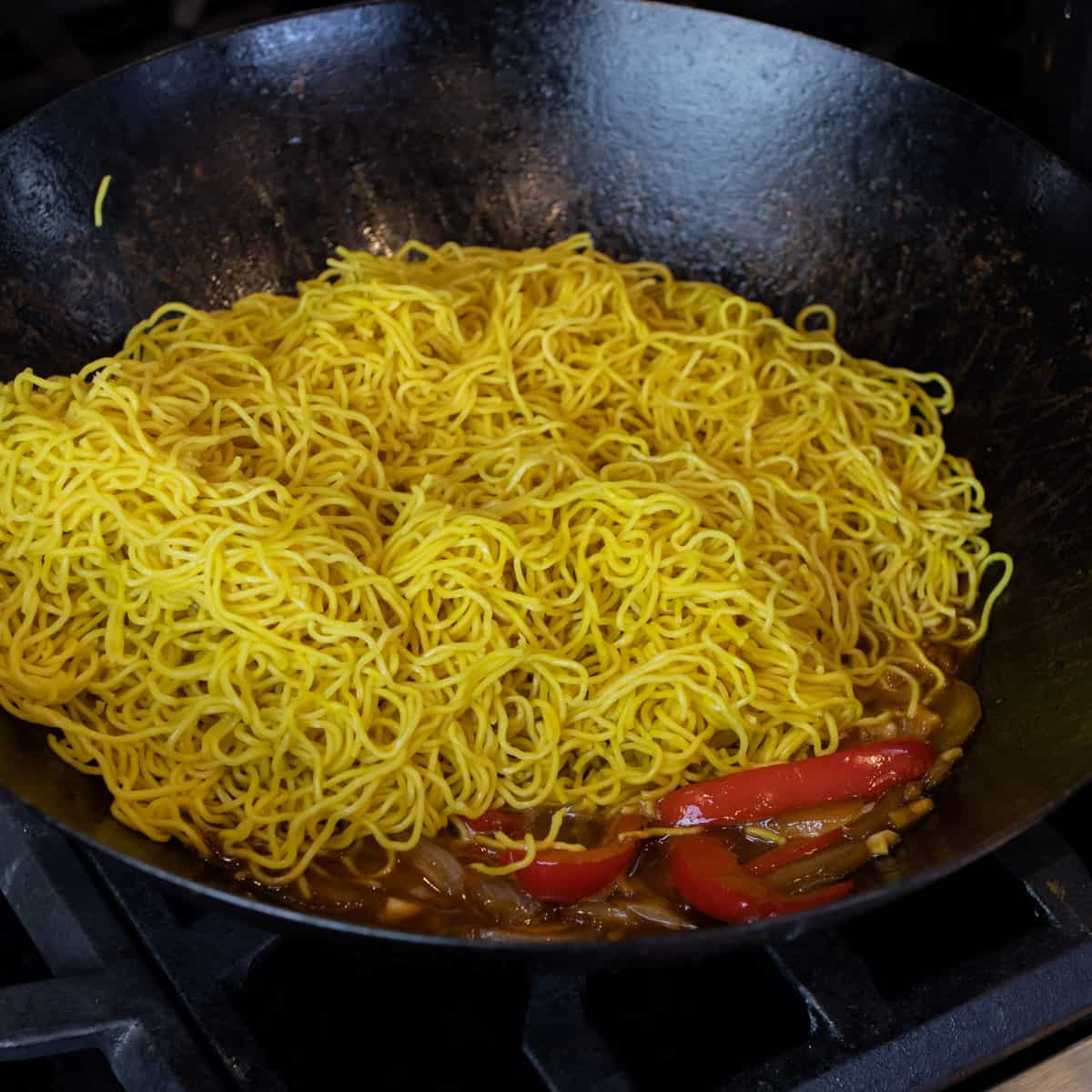 Cooked Chinese noodles in a hot wok.