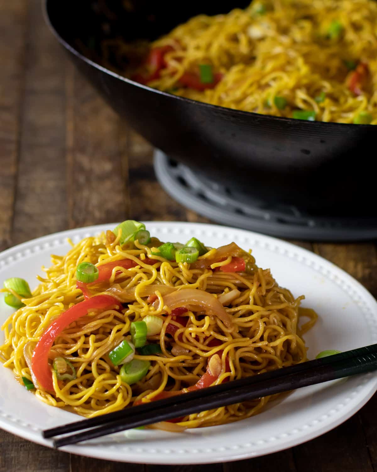 Chinese noodles on a plate with chopsticks.