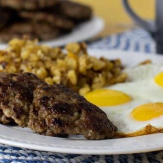 A plate of sausage patties, eggs and hash brown potatoes.
