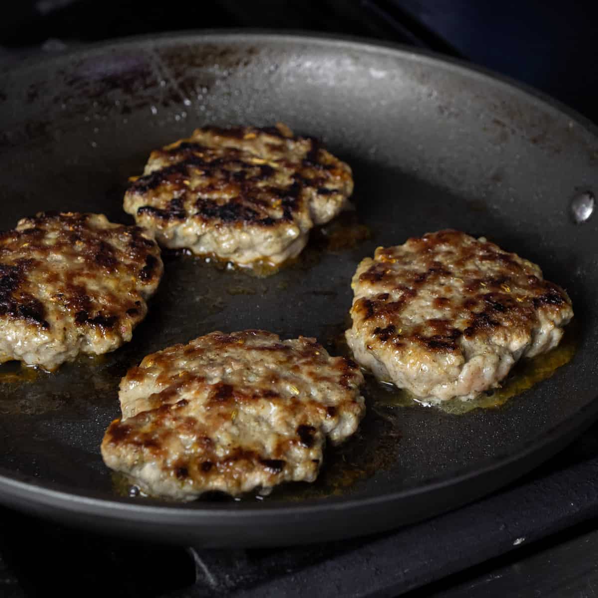 Cooked sausage patties in a skillet.