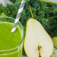 A close up picture of a smoothie in a glass and a sliced pear.