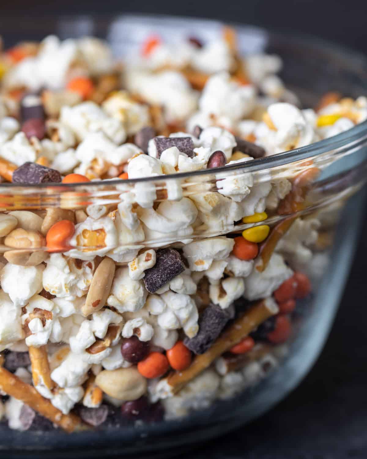 A glass box filled with popcorn, nuts and other snacks.