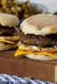 Two breakfast sandwiches on a board of wood.