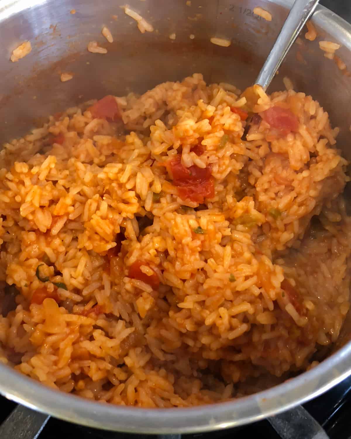 Cooked rice in a pot that has simmered with salsa.