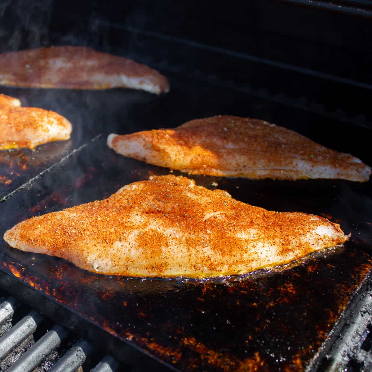 Fish cooking on a grilling stone.
