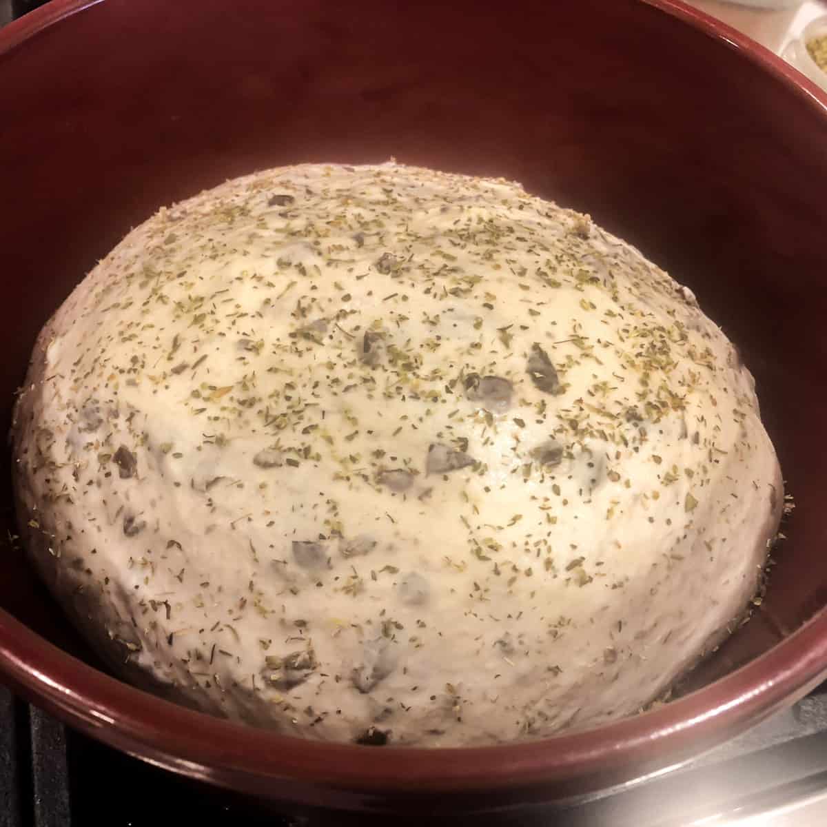Raw bread dough risen and placed in a dutch oven.