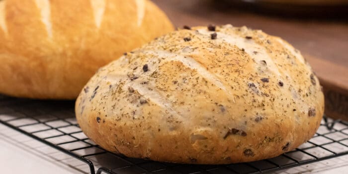 Two Loaves of rustic round bread on a cooling rack.