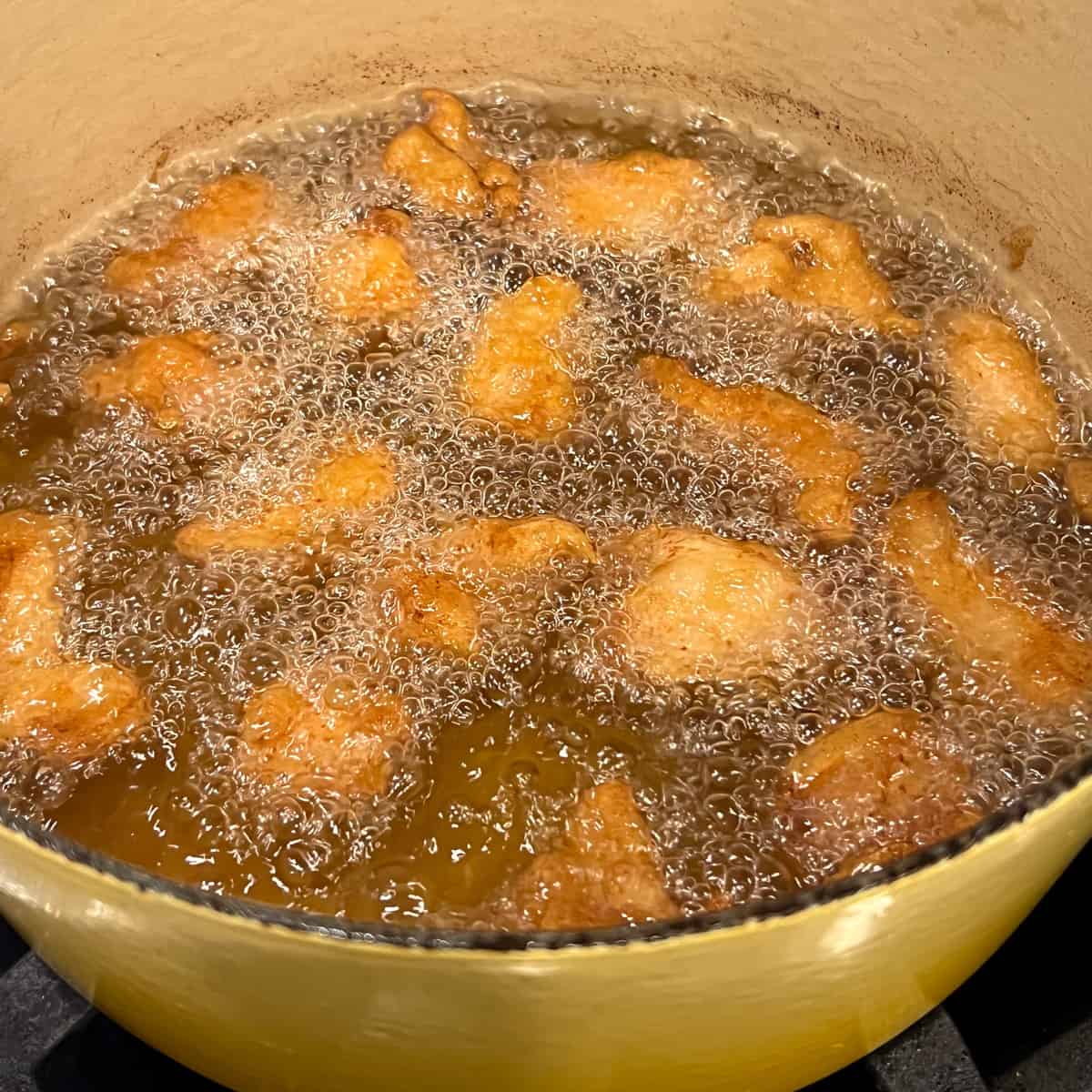 Frying battered chicken in hot oil.