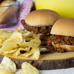 Two sloppy joes on a board.