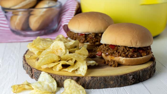 Two sloppy joes on a board.