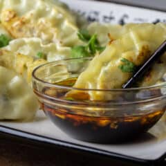 Close up picture of a dumpling dipped in sauce.