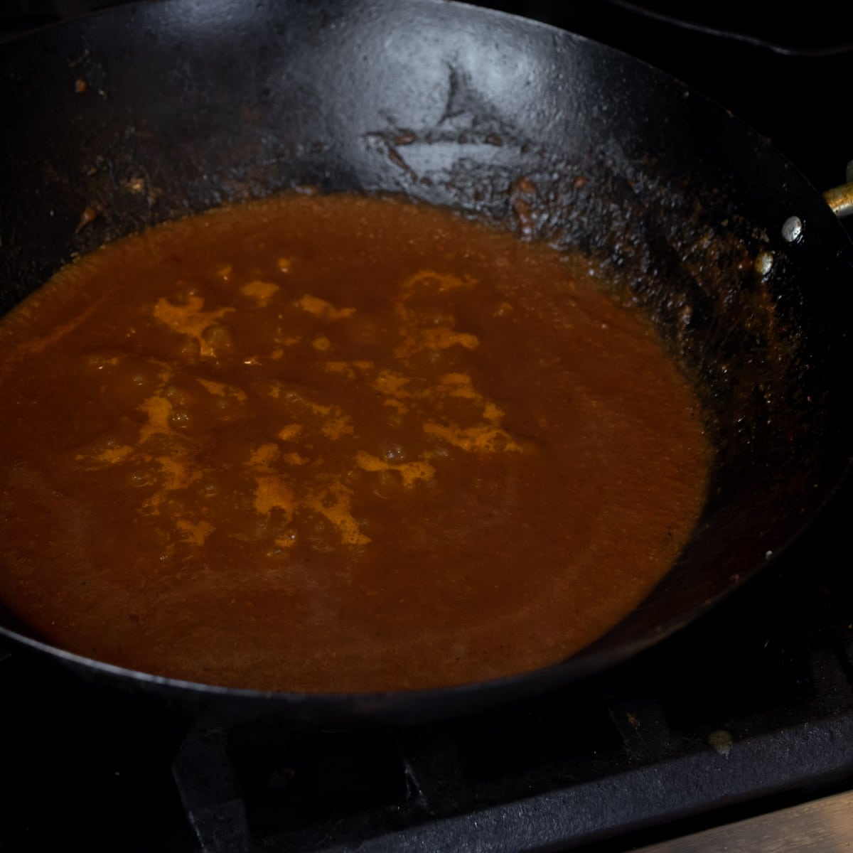 Sauce simmering with tiny bubbles visible.