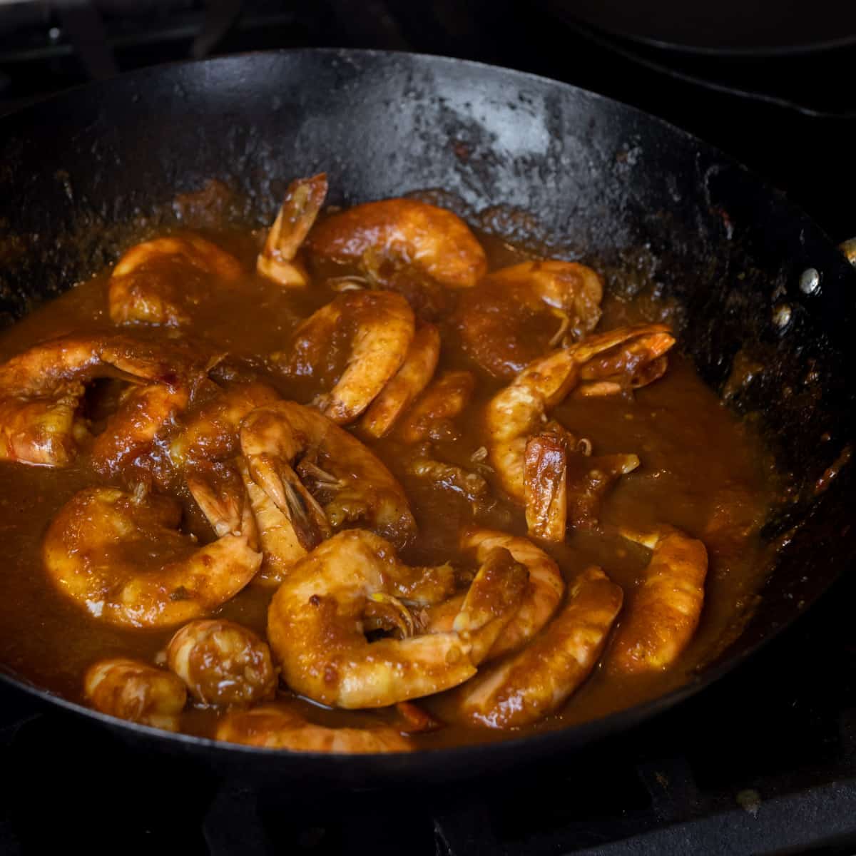 Cooked shrimp coated in sauce.
