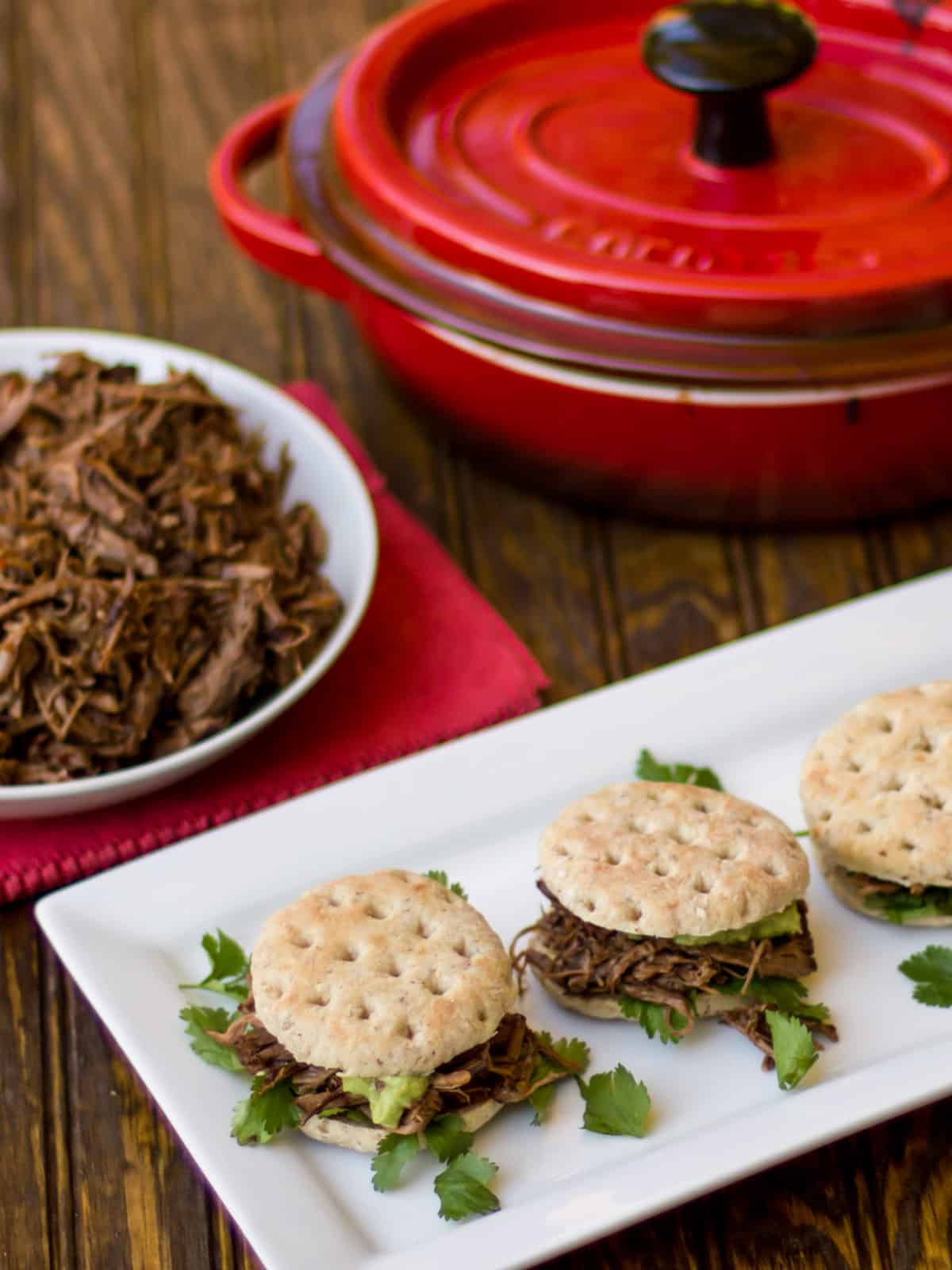 Overhead picture of sliders and bowl of shredded beef.