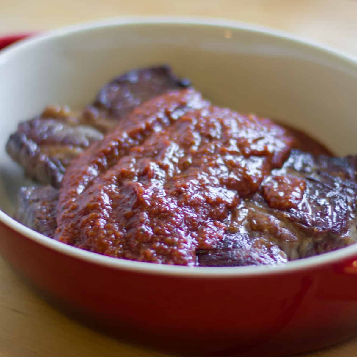 Baking dish with beef and sauce.