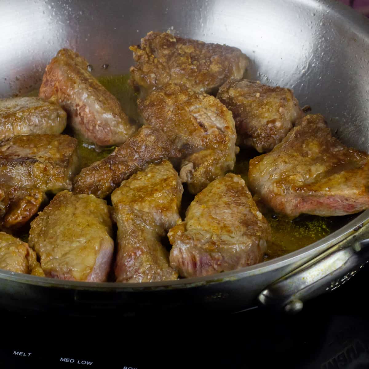 Stewing beef in a frying pan browning.