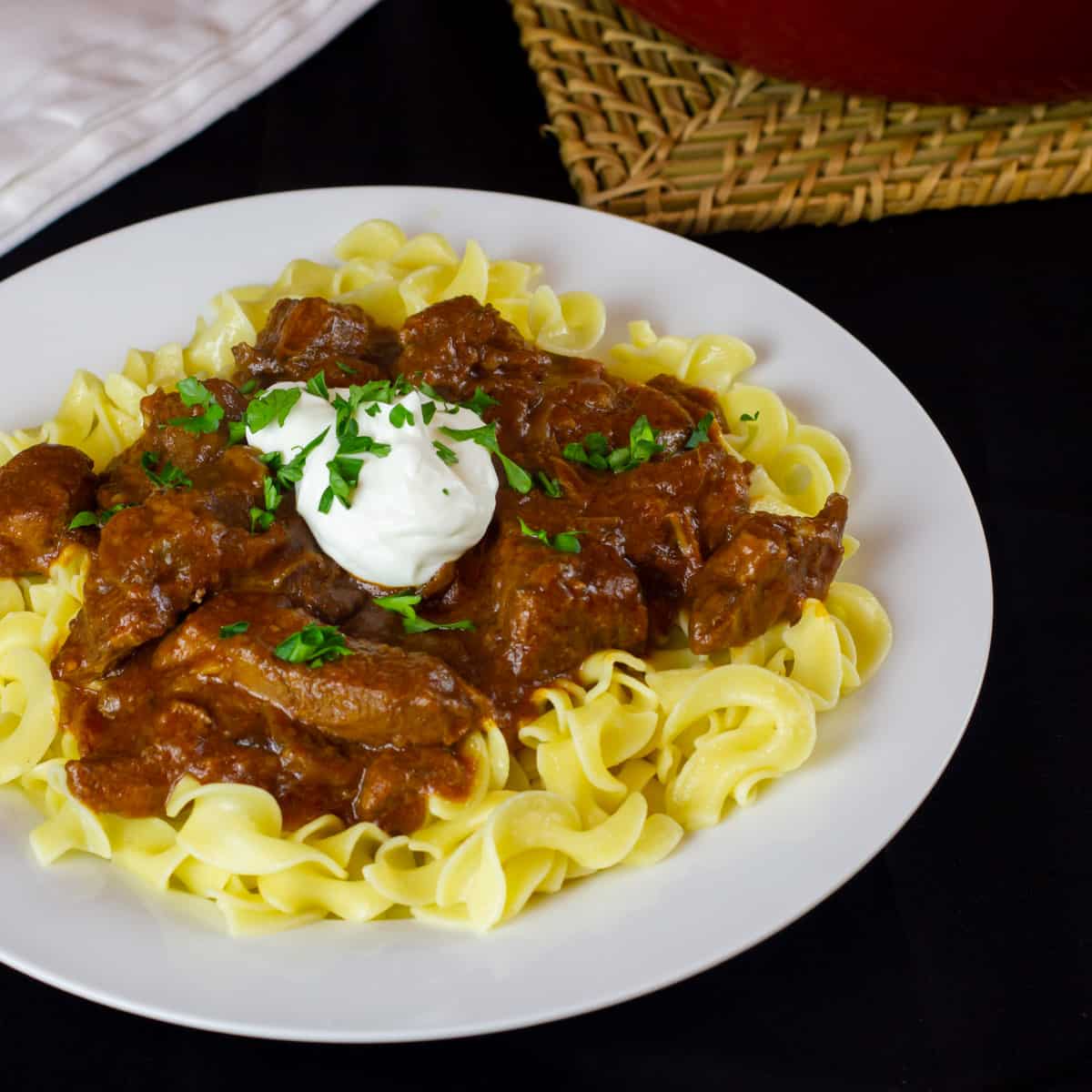 Overhead picture of goulash on a bed of egg noodles.