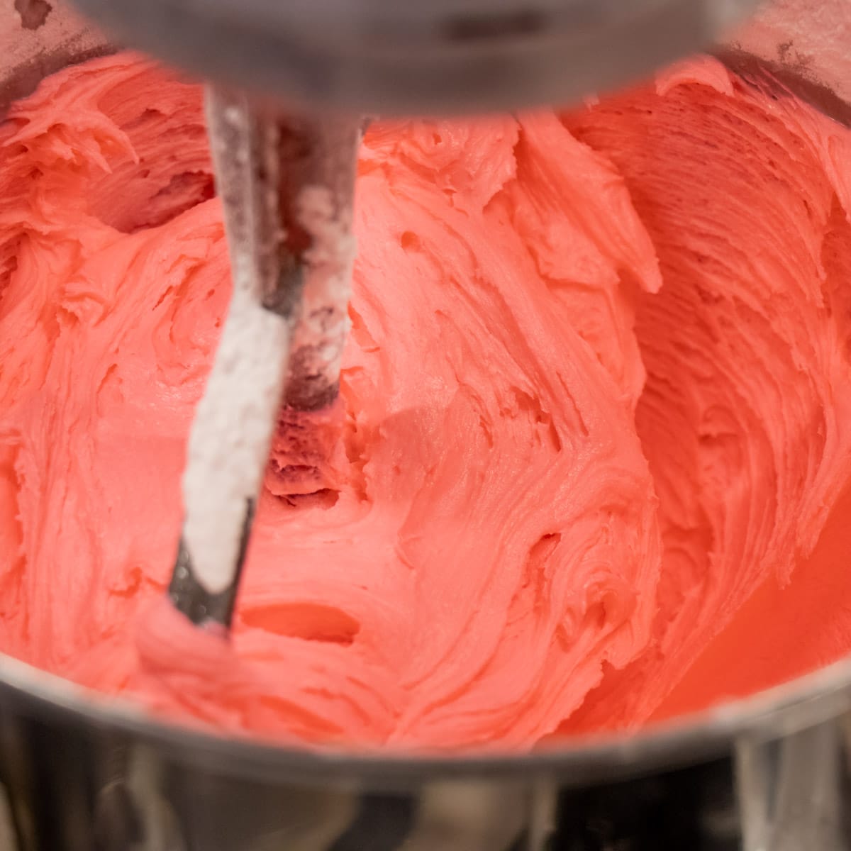 Frosting being mixed in a stand mixer.