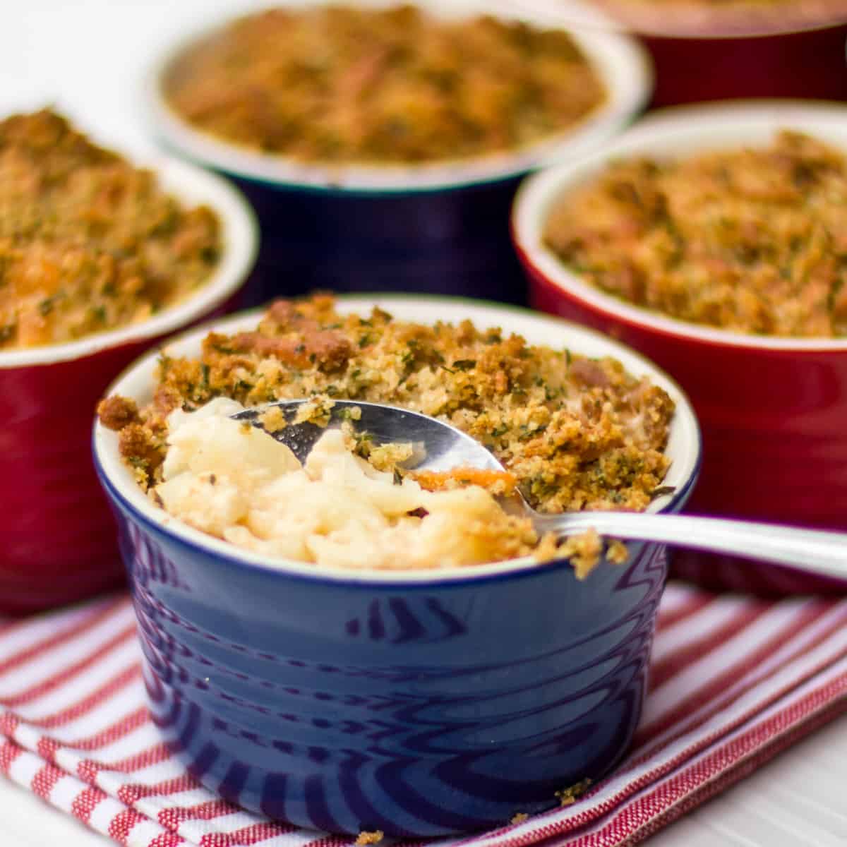 Using a spoon to scoop some macaroni and cheese out of a small bowl.