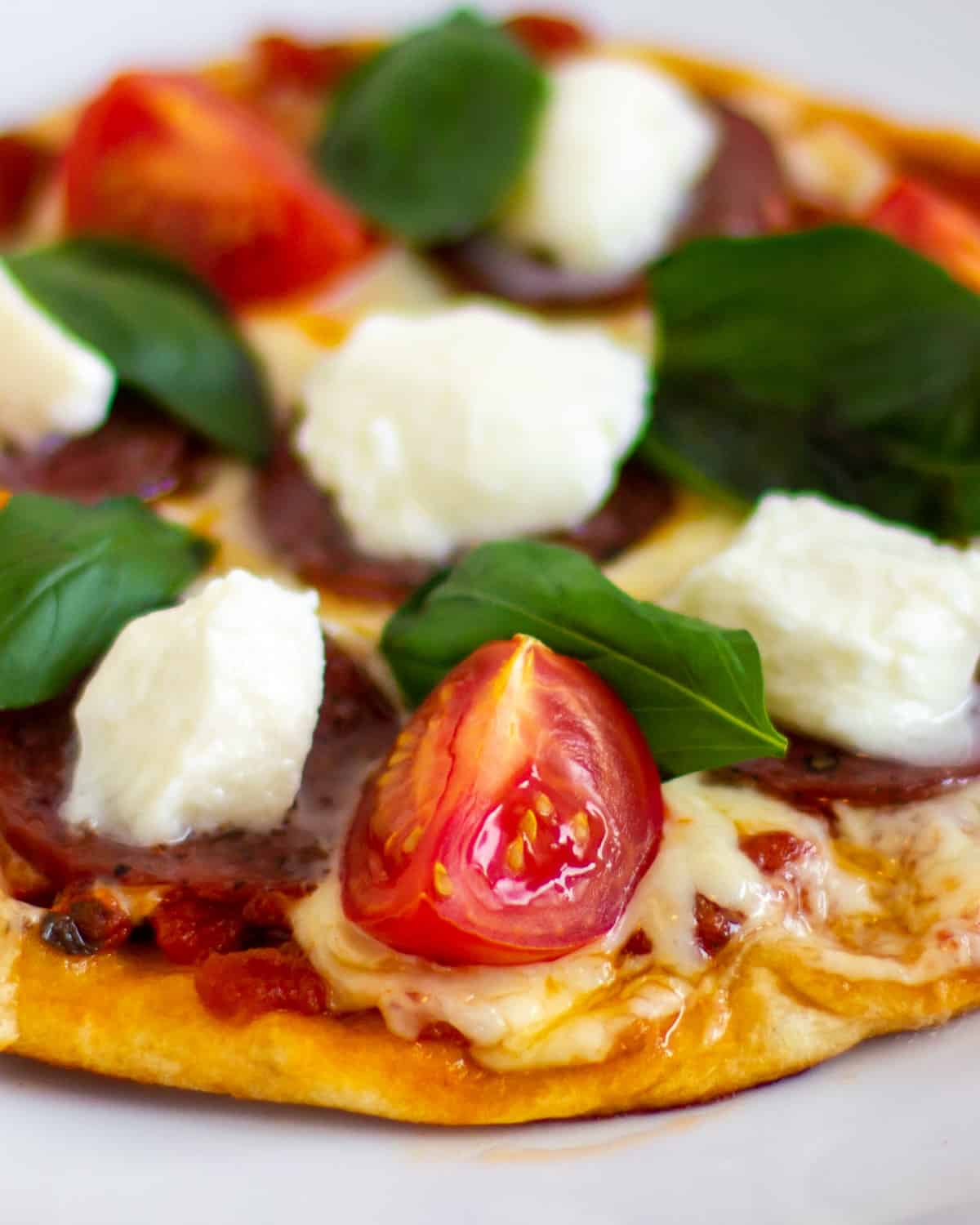 A close up picture of a pizza with fresh basil on top.