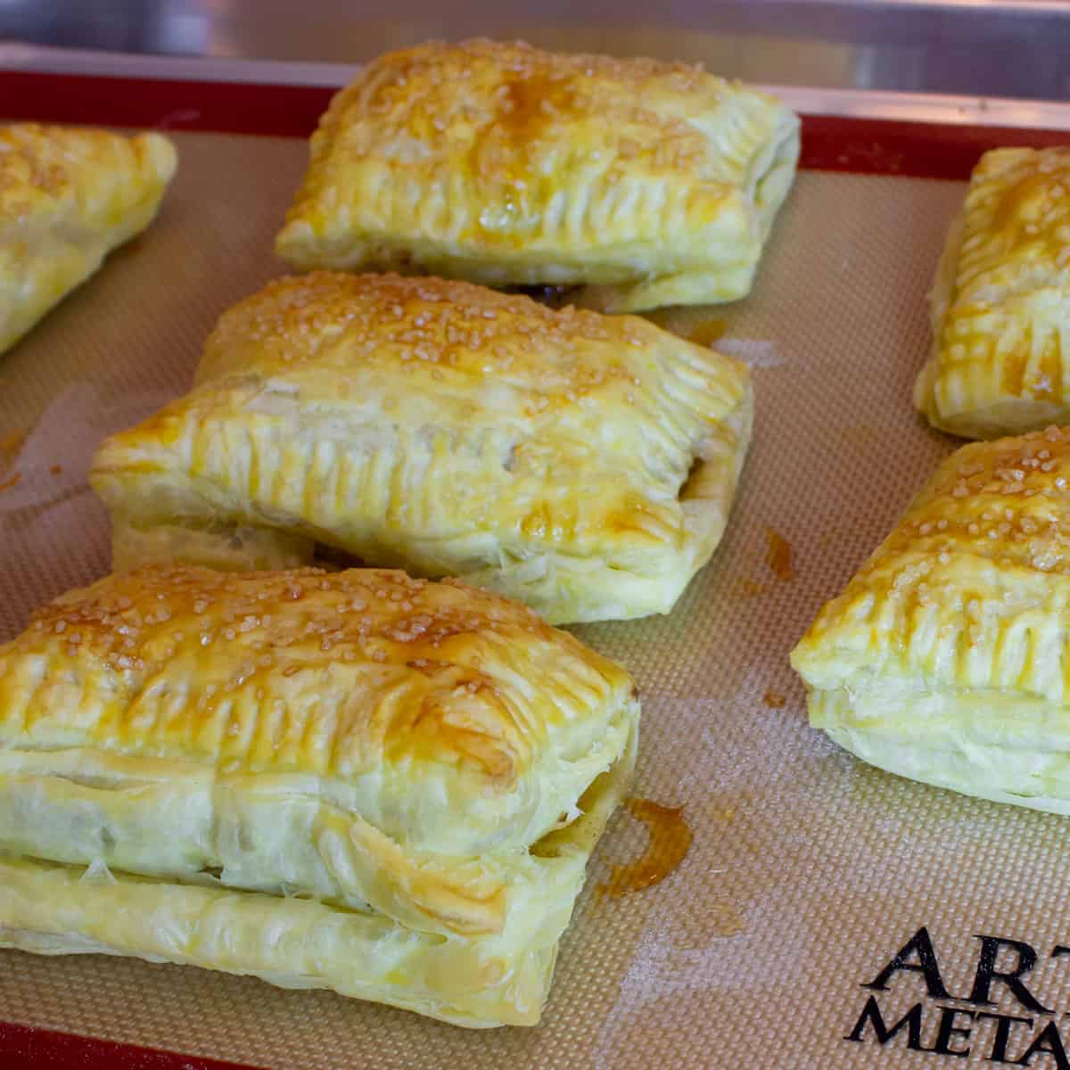 Freshly baked turnovers on a baking sheet.