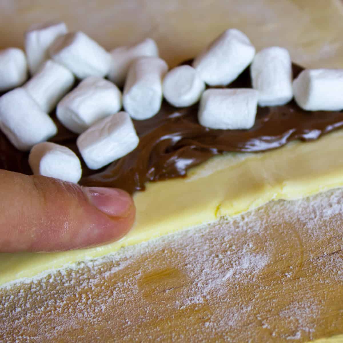 Using a finger to wet the corners of puff pastry.