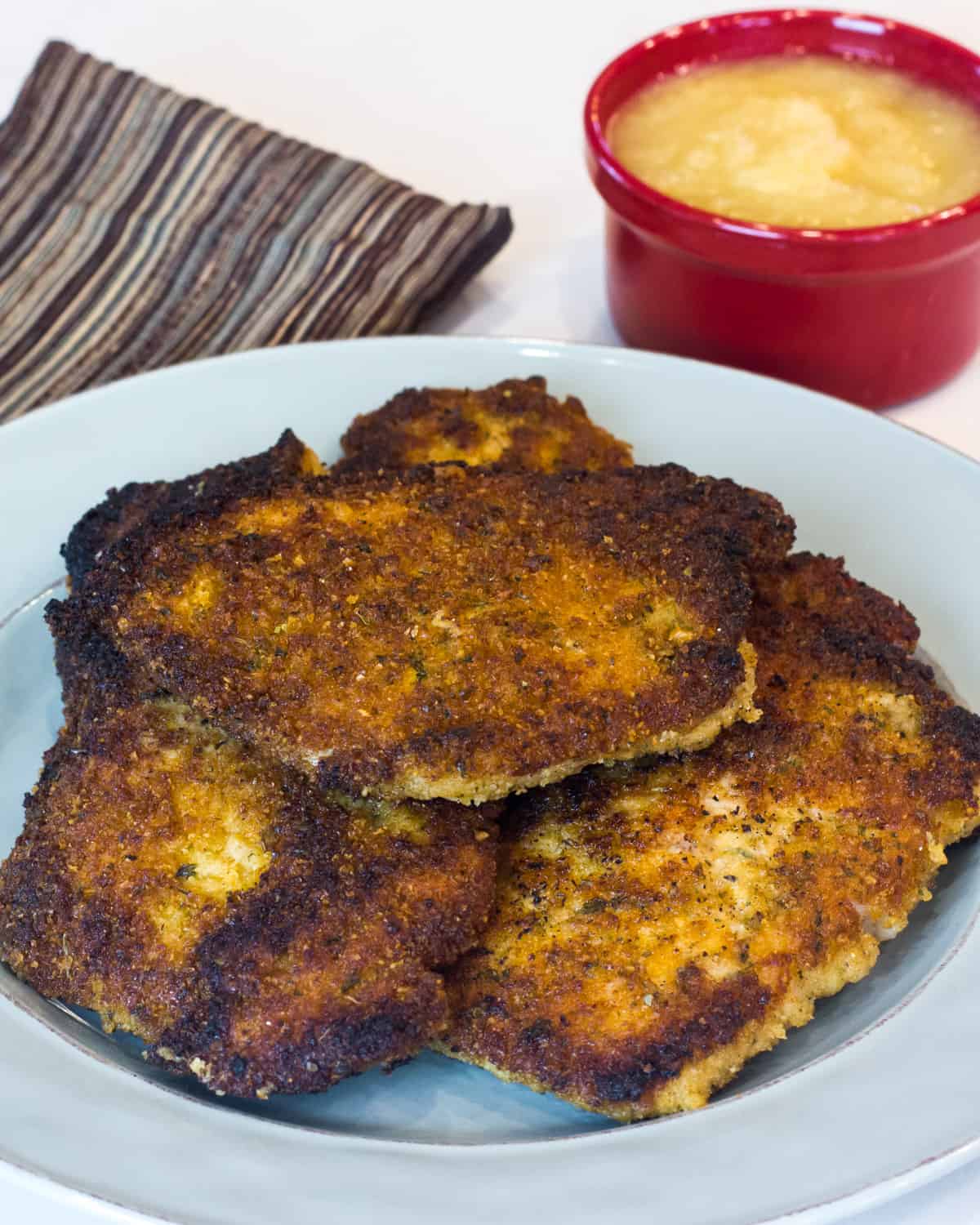 Three pork cutlets on a plate.