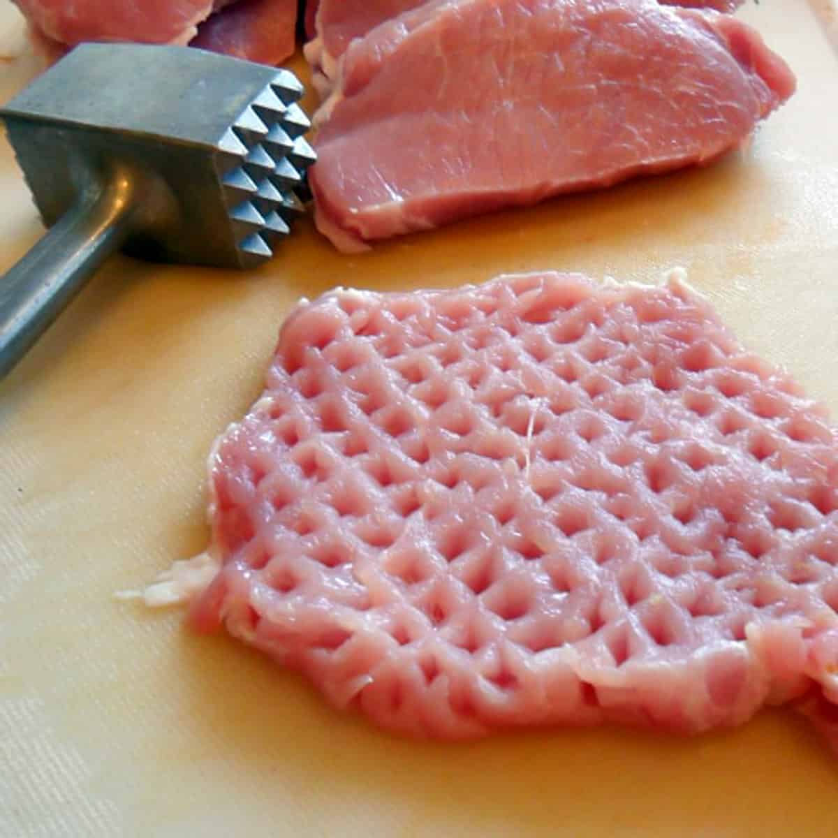 Using a meat hammer to tenderise pork cutlet.