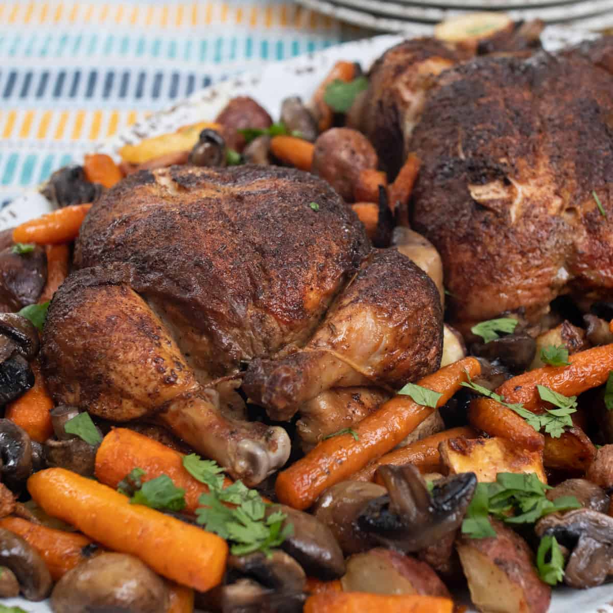 Close up picture of cooked chickens and vegetables on a platter.