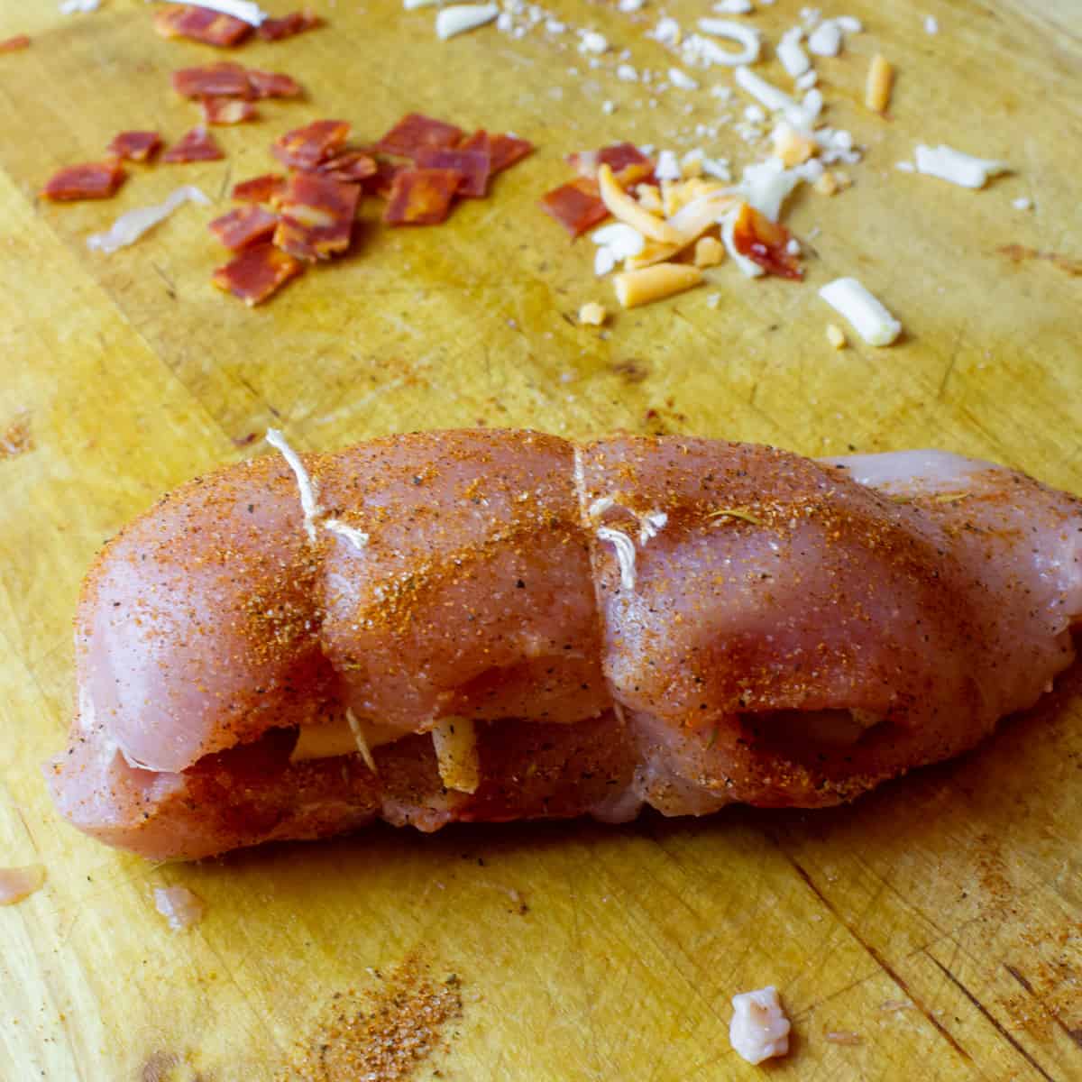Stuffed chicken breast that has been tied up with kitchen twine.