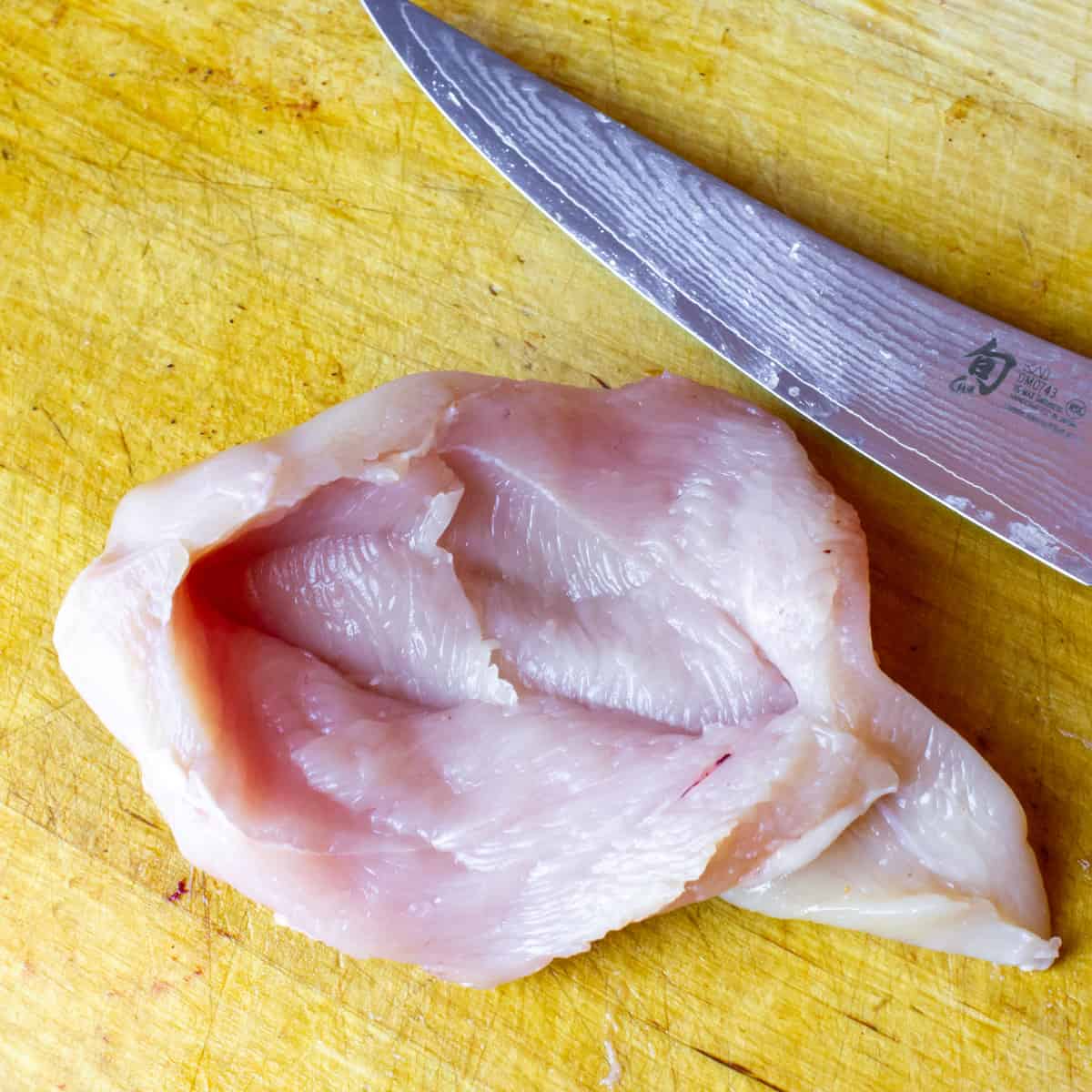 A chicken breast with a pocket sliced into the centre.