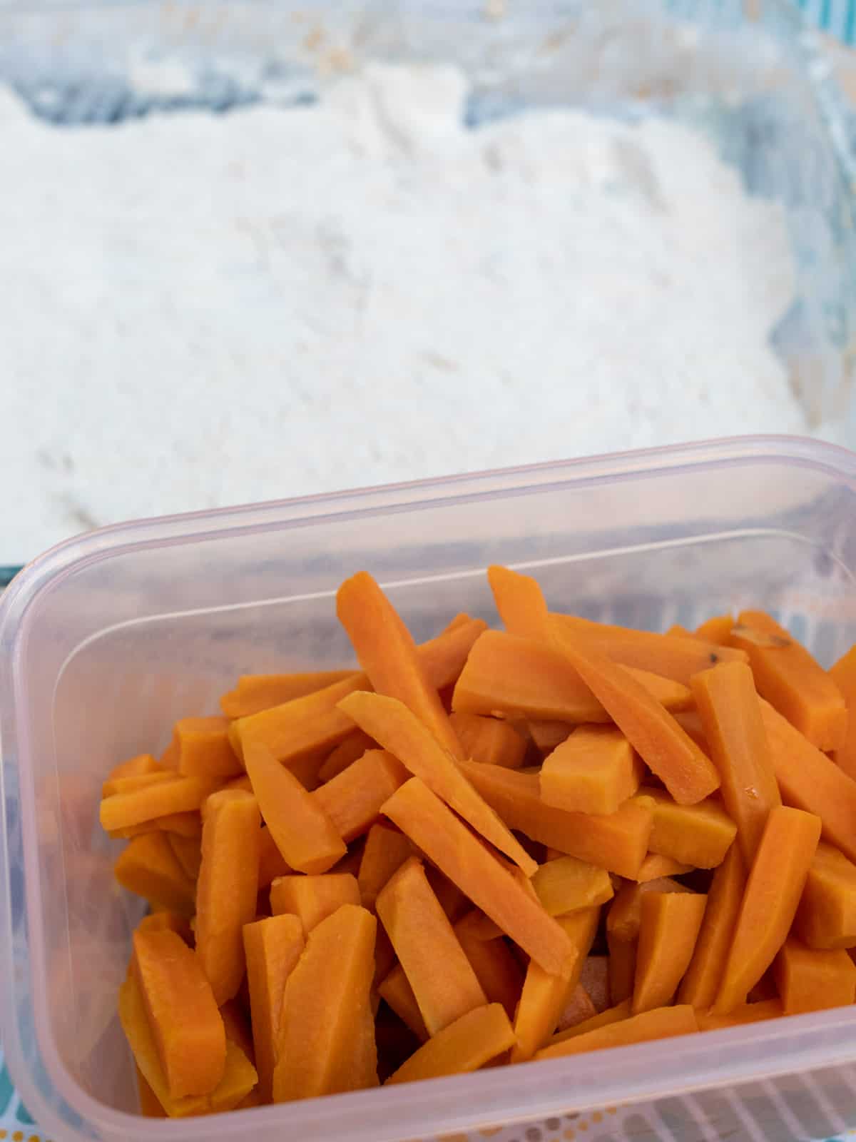 Blanched fries in a plastic container.