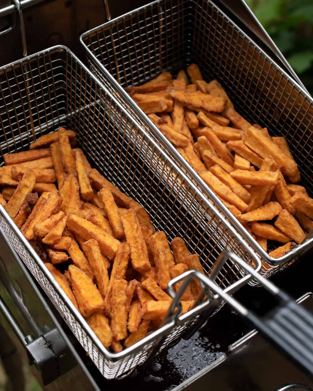 Deep fried sweet potato fries draining in the baskets.
