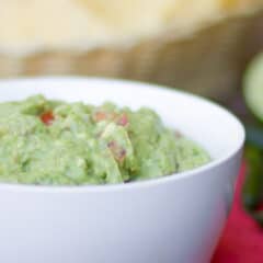 A close up picture of a bowl of mashed avocado.