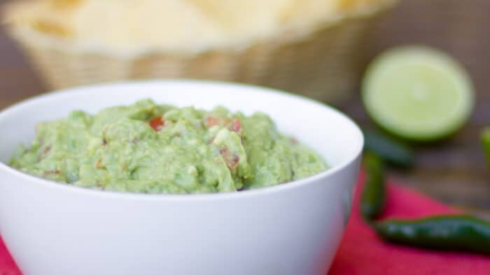 A close up picture of a bowl of mashed avocado.