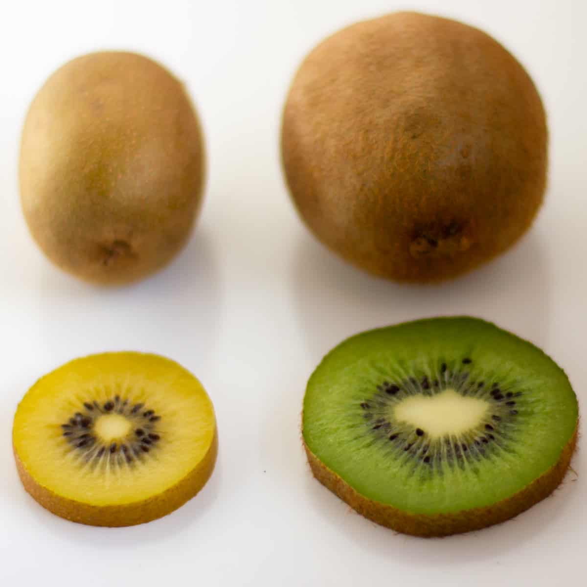 Two different kinds of kiwi sliced next to each other.