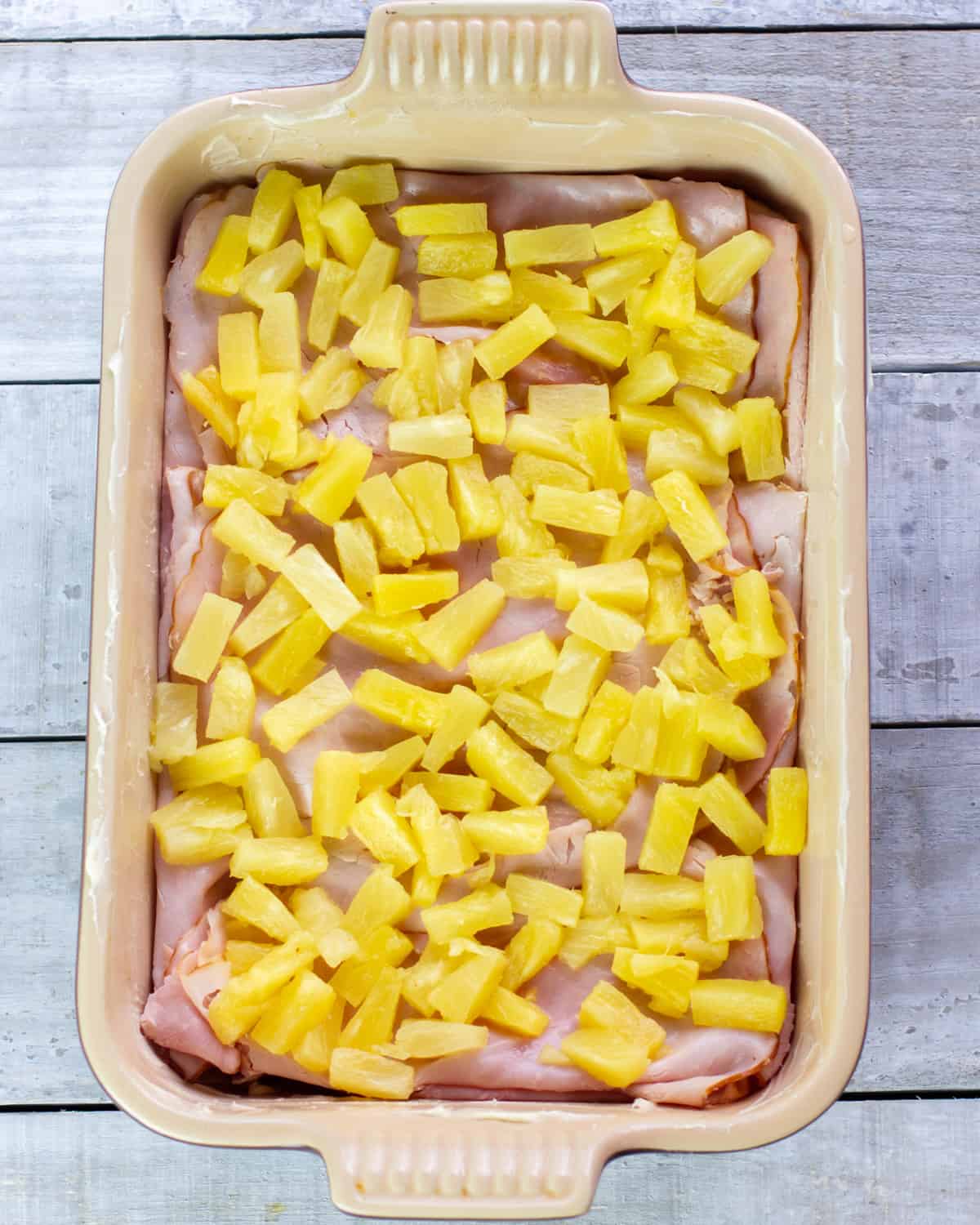 Pineapple pieces piled on sliced ham.