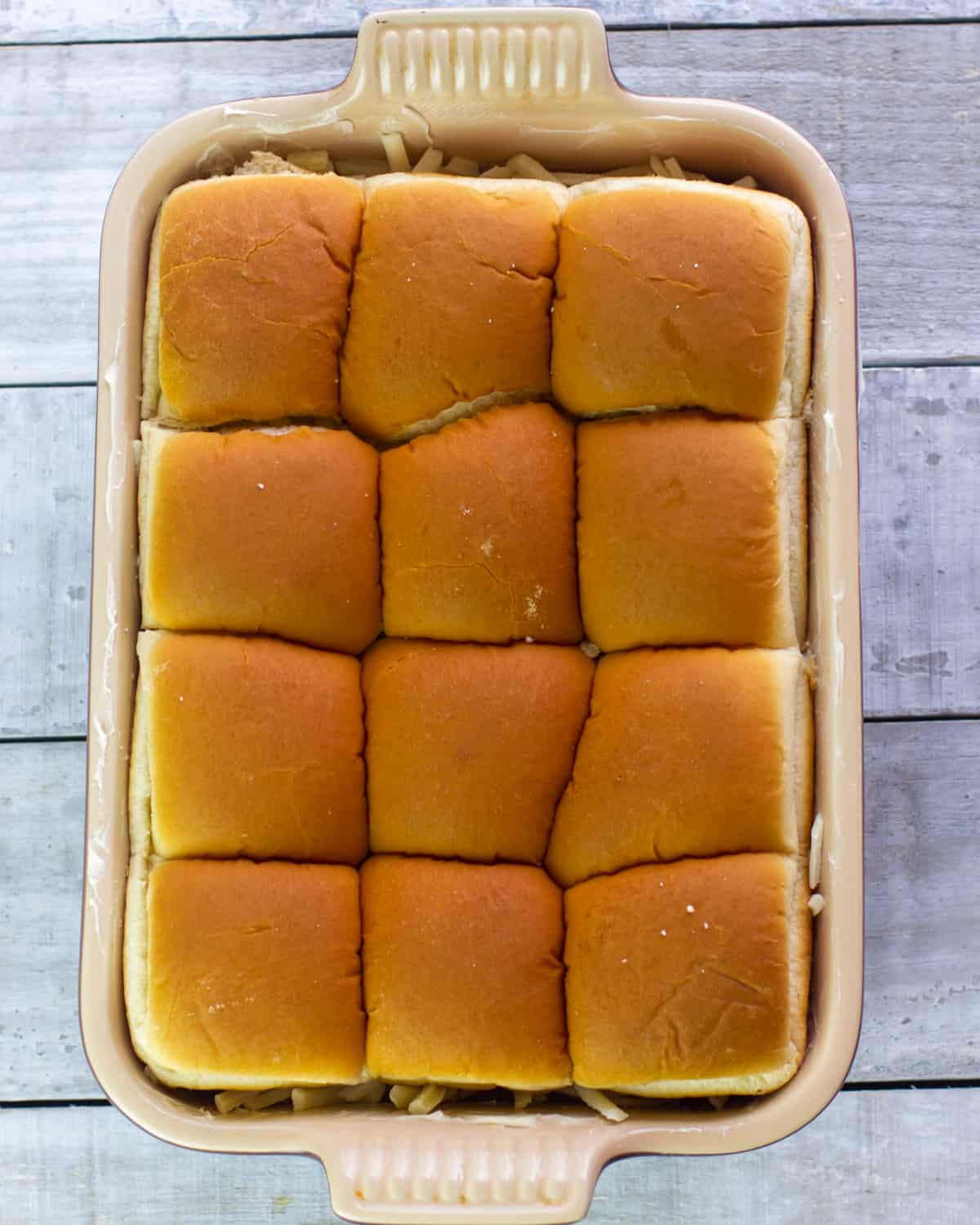 Sliders in a baking dish and ready to go in the oven.