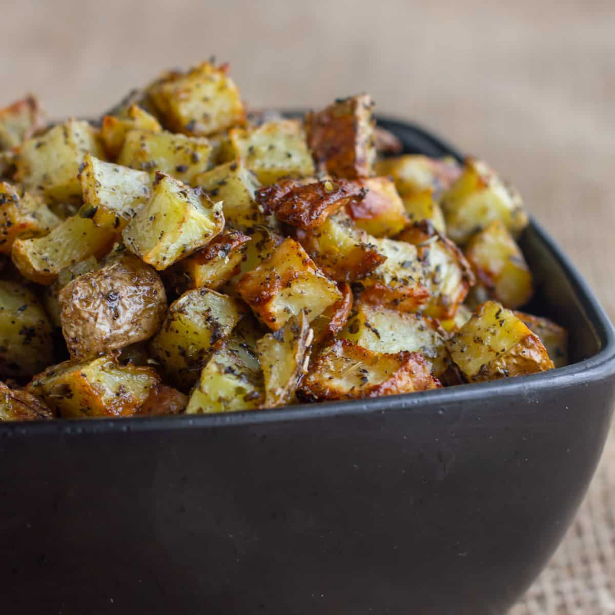 Side image of a black bowl filled with potatoes.