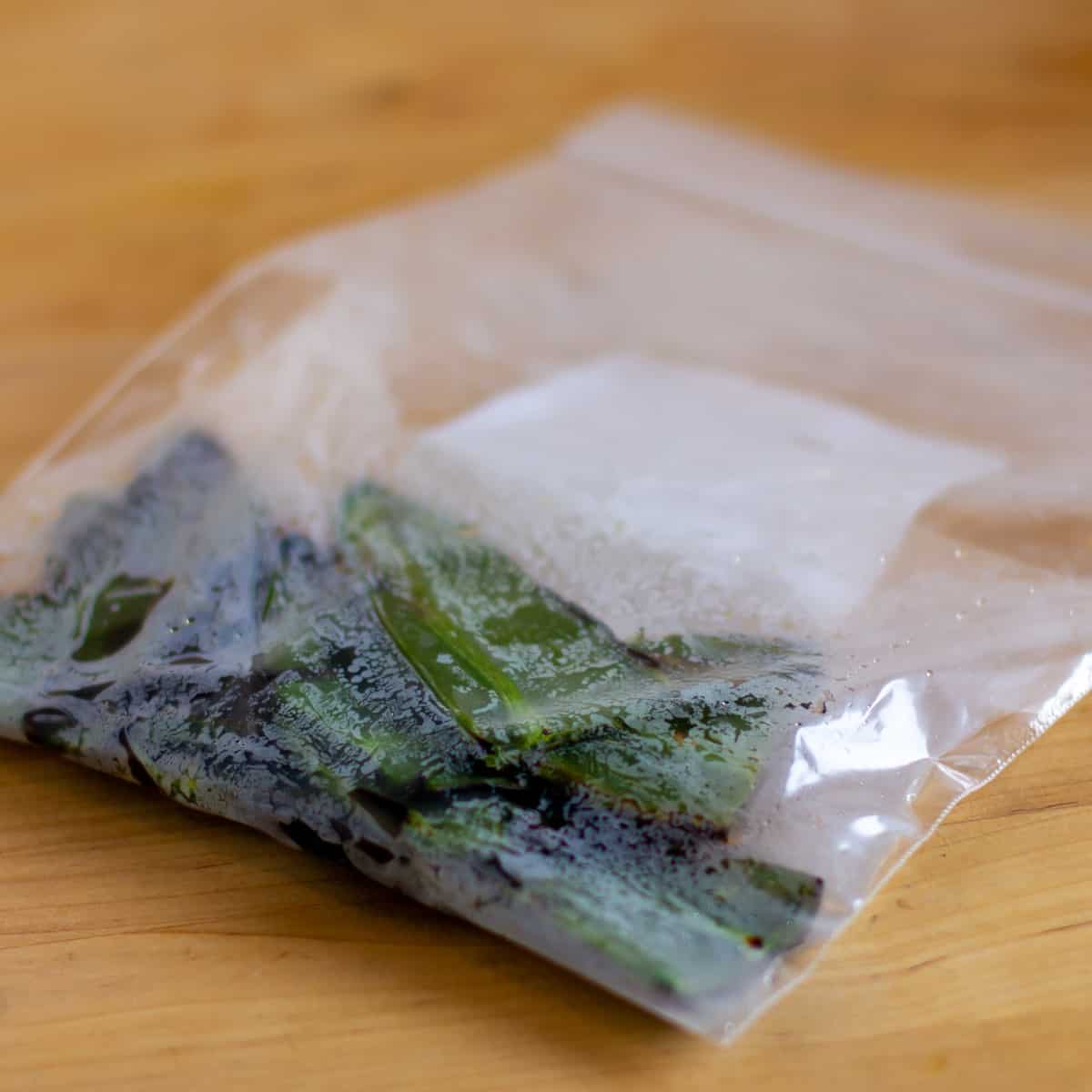 Roasted peppers in a freezer bag that is showing steam and moisture on the plastic bag.