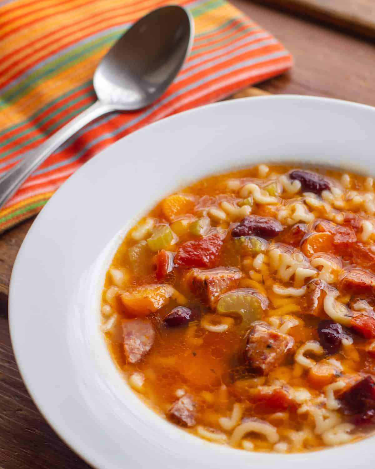 Close up picture of a bowl of soup with a spoon.