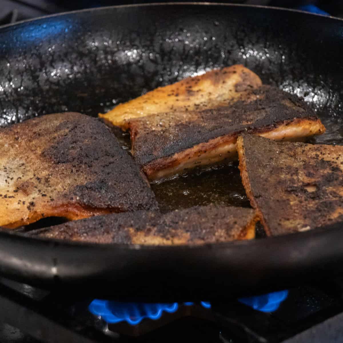 Fish in a skillet, skin side up.