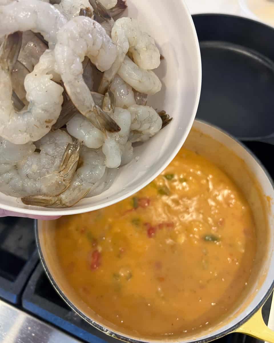 Raw shrimp being added to the pot.